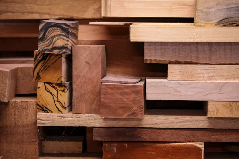 A varied stack of natural wood samples showing different grains and tones.